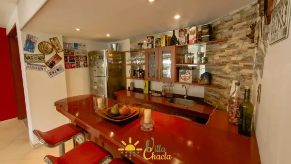 Acogedora sala de estar con asientos de cuero y Smart TV, perfecta para noches de películas y reuniones cómodas.