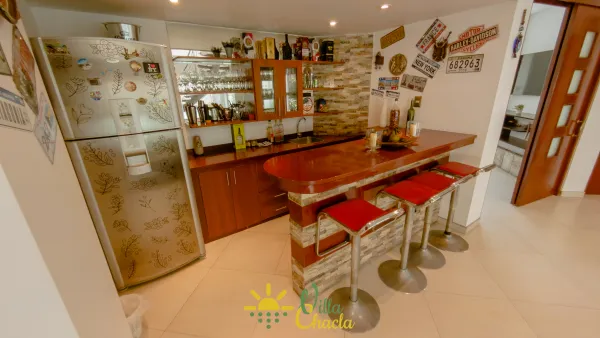 Acogedora sala de estar con asientos de cuero y Smart TV, perfecta para noches de películas y reuniones cómodas.