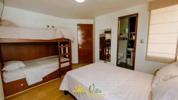 Habitación 3.La opción más espaciosa y versátil. Equipada con una cama de 2 plazas, una litera con dos camas de plaza 1/2 y un cómodo sofá, perfecta para alojar hasta cuatro personas. Disfrute de su amplio diseño, suelos de madera y gran armario abierto. Baño completo privado y smart tv incluido.