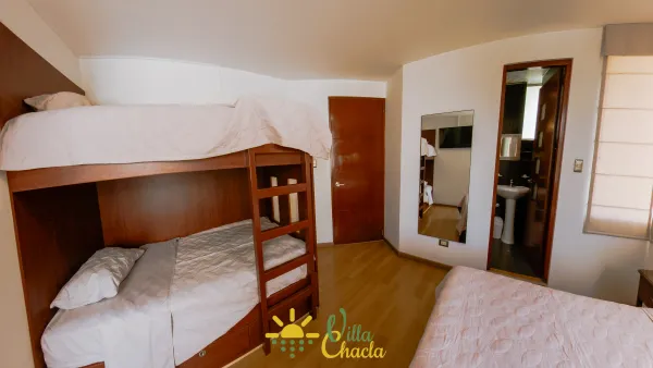 Habitación 3.La opción más espaciosa y versátil. Equipada con una cama de 2 plazas, una litera con dos camas de plaza 1/2 y un cómodo sofá, perfecta para alojar hasta cuatro personas. Disfrute de su amplio diseño, suelos de madera y gran armario abierto. Baño completo privado y smart tv incluido.