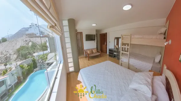 Habitación 4. Espacio elegante y lleno de energía con un vibrante muro de acento color dorado. Disfrute de una cómoda cama queen, amplio espacio de almacenamiento en el armario abierto y un práctico tocador/escritorio. Ideal para parejas que buscan un refugio acogedor con baño privado y smart tv.